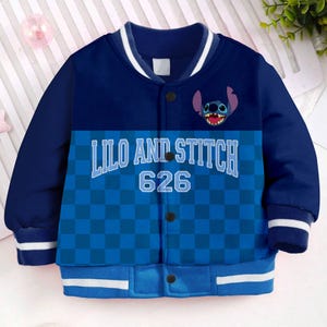 May include: Blue and white baseball jacket with a checkered pattern and a blue Stitch character from Lilo & Stitch. The jacket has a white collar and cuffs and says "Lilo and Stitch 626" on the front.