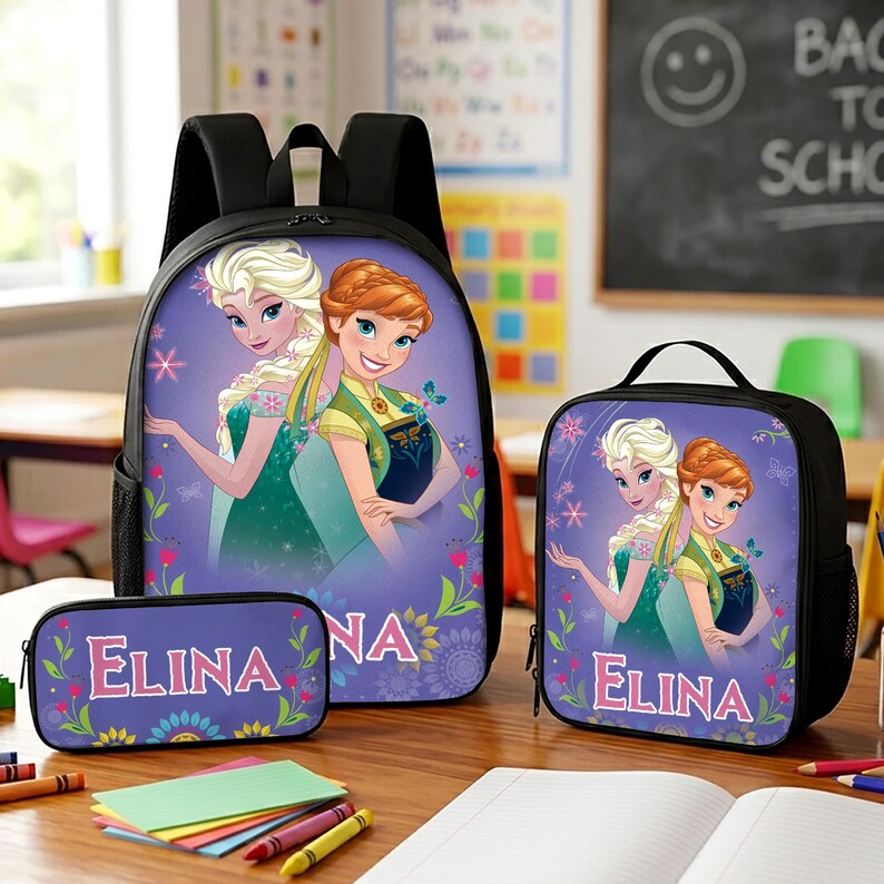 May include: A black backpack, lunch bag, and pencil case set featuring a purple graphic print of two animated characters with blonde and auburn hair. Each item displays the name ELINA in pink lettering with floral and butterfly accents.