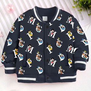 May include: A navy blue bomber jacket with white stripes on the collar and cuffs. The jacket features a repeating pattern of Mickey Mouse, Donald Duck, Goofy, and the letters M, G, and P.