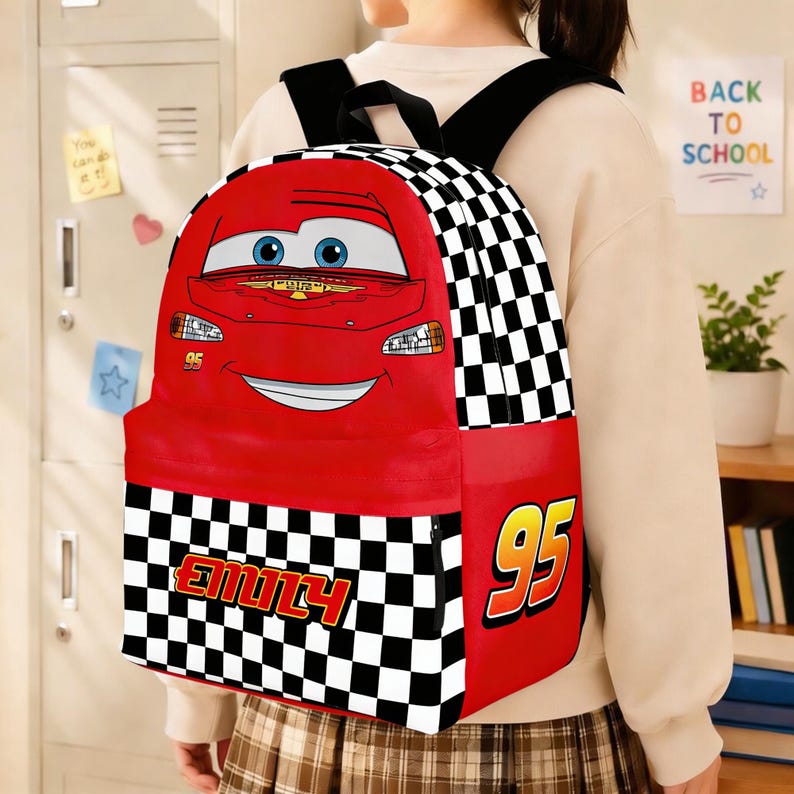 Peut inclure: Un sac &agrave; dos rouge avec Flash McQueen du film Cars. Le sac &agrave; dos pr&eacute;sente une grande image du visage du personnage, le num&eacute;ro "95" et un motif &agrave; carreaux. Le nom "EMILY" est imprim&eacute; sur le devant.