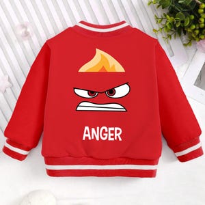 May include: Red bomber jacket with a white stripe on the collar, cuffs, and hem. The back of the jacket features a cartoon image of Anger from the movie Inside Out, with the word "ANGER" printed below the image.