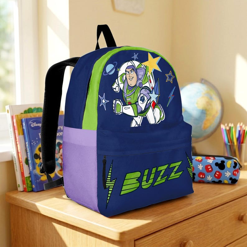 May include: A dark blue backpack featuring a graphic of Buzz Lightyear in a space suit, surrounded by stars and planets. The front pocket displays the text BUZZ in large green letters with lightning bolt accents. It has lime green and purple side panels.