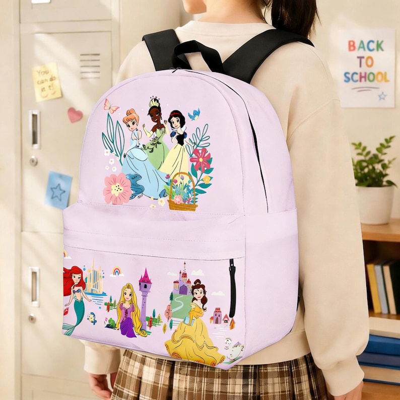 May include: A light purple backpack featuring illustrations of Disney princesses. The backpack has a front pocket with a zipper and black shoulder straps. The top of the backpack has a floral design with three princesses. The bottom of the backpack has illustrations of other princesses and castles.