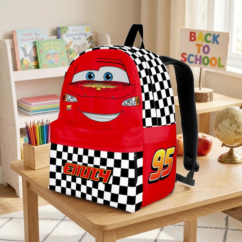 Peut inclure: Sac &agrave; dos rouge Lightning McQueen avec un motif &agrave; carreaux noir et blanc. Le sac &agrave; dos porte le num&eacute;ro 95 et le nom "Emily". Il a des bretelles noires et une poign&eacute;e sup&eacute;rieure. Un sac &agrave; dos amusant et color&eacute; pour l'&eacute;cole.