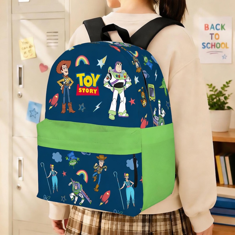 May include: A navy blue backpack featuring characters from the movie "Toy Story." The backpack has a green front pocket and straps. The design includes Woody, Buzz Lightyear, and the words "Toy Story."