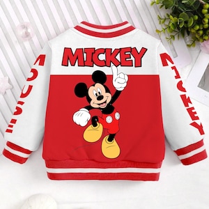 May include: A white and red bomber jacket featuring Mickey Mouse. The back of the jacket has the word "MICKEY" in large red letters and a cartoon image of Mickey Mouse. The sleeves have the word "MICKEY" in red.