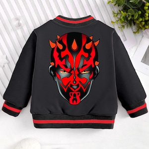 May include: Black sweatshirt with red and black striped cuffs and collar. The sweatshirt features a large graphic print of Darth Maul's face.