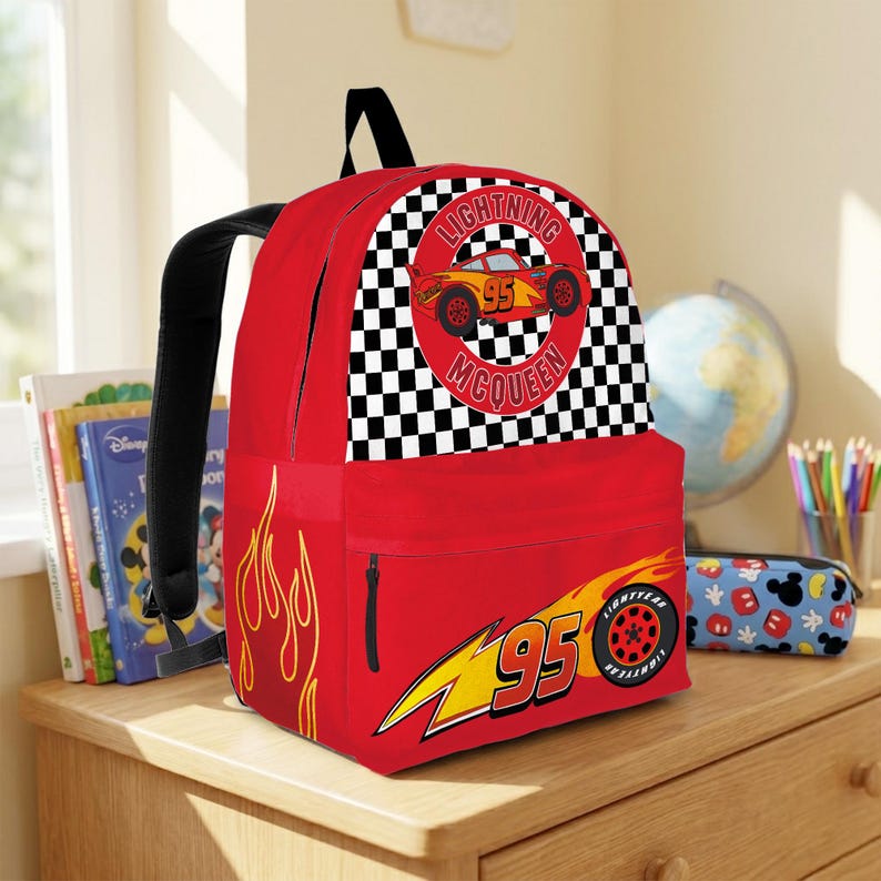 May include: A red Lightning McQueen backpack with a black checkered pattern and the words "Lightning McQueen" and "95". The backpack has a front pocket with a zipper and a side pocket.