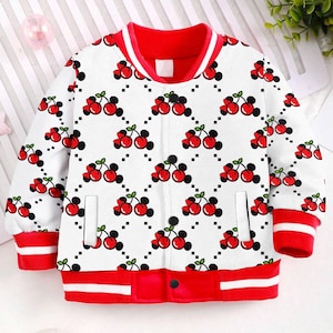 May include: A white bomber jacket with red trim and a pattern of red cherries on a white background.
