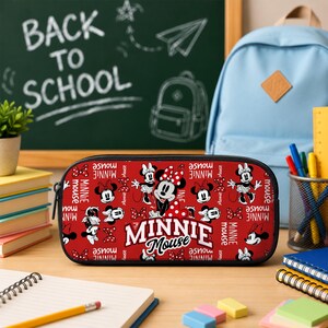 Pu&ograve; includere: Un astuccio rettangolare con uno sfondo rosso vivace caratterizzato da un motivo ripetuto di personaggi di Minnie Mouse, fiocchi bianchi a pois e la scritta Minnie Mouse in grassetto bianco al centro del pannello frontale.