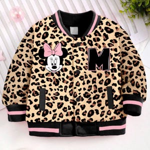 May include: A brown and black leopard print bomber jacket with a pink and black Minnie Mouse graphic on the left side and a black letter 'M' on the right side. The jacket has pink and black ribbed trim.