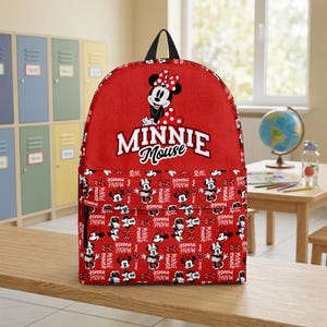 May include: Red Minnie Mouse backpack with a black top handle and adjustable straps. The front features Minnie Mouse and the words "MINNIE Mouse". The bottom section has a pattern of Minnie Mouse and the words "MINNIE mouse".