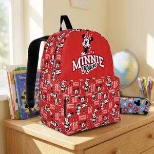 May include: Red Minnie Mouse backpack with black straps. The backpack features a large Minnie Mouse graphic and the words "Minnie Mouse" in white. The main body of the backpack is covered in a pattern of Minnie Mouse illustrations and the words "Minnie Mouse".