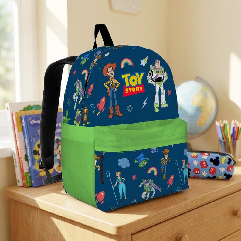 May include: A blue backpack featuring characters from Toy Story, including Woody and Buzz Lightyear, with a green front pocket and black straps. The backpack has a Toy Story logo and illustrations of rockets and rainbows.