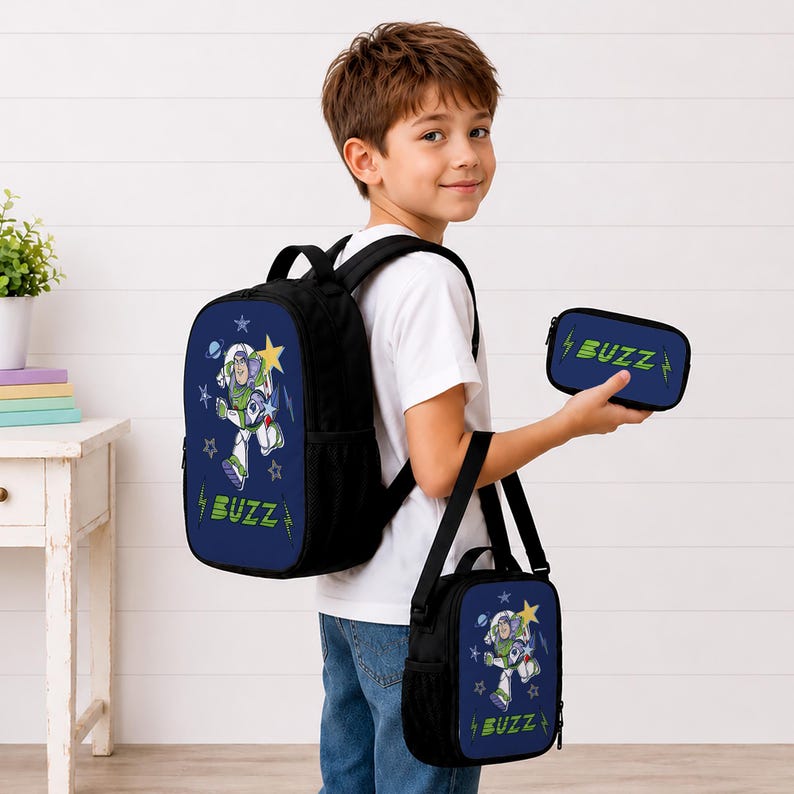 May include: A black backpack, a matching lunch bag, and a small pencil case, all featuring a blue front panel with a graphic of Buzz Lightyear, yellow stars, and the text BUZZ in green. The items have black straps and side mesh pockets.