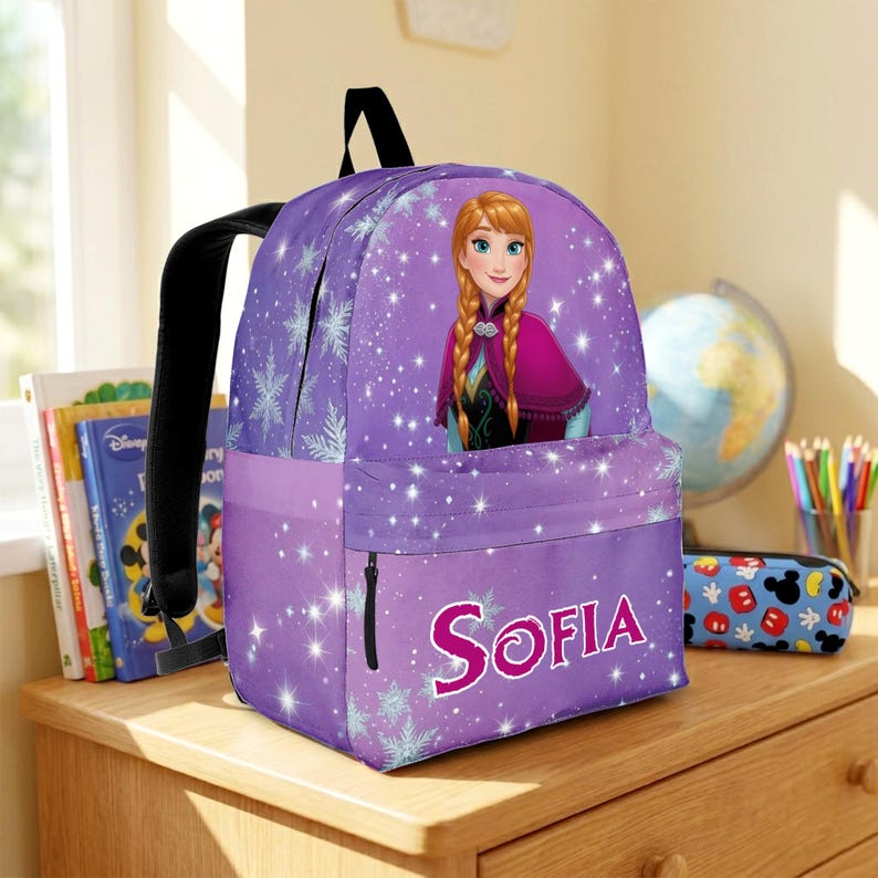 Pu&ograve; includere: Uno zaino viola con una grafica di Anna di Frozen con i capelli intrecciati, circondata da motivi a fiocchi di neve bianchi e stelle scintillanti. La tasca frontale mostra il nome Sofia in grandi lettere rosa con un bordo scuro.