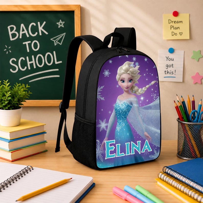 May include: A black backpack featuring a graphic print of a blonde character in a blue dress with the name ELINA printed in white letters. The backpack has a top handle, adjustable shoulder straps, and a side mesh pocket on a purple background.