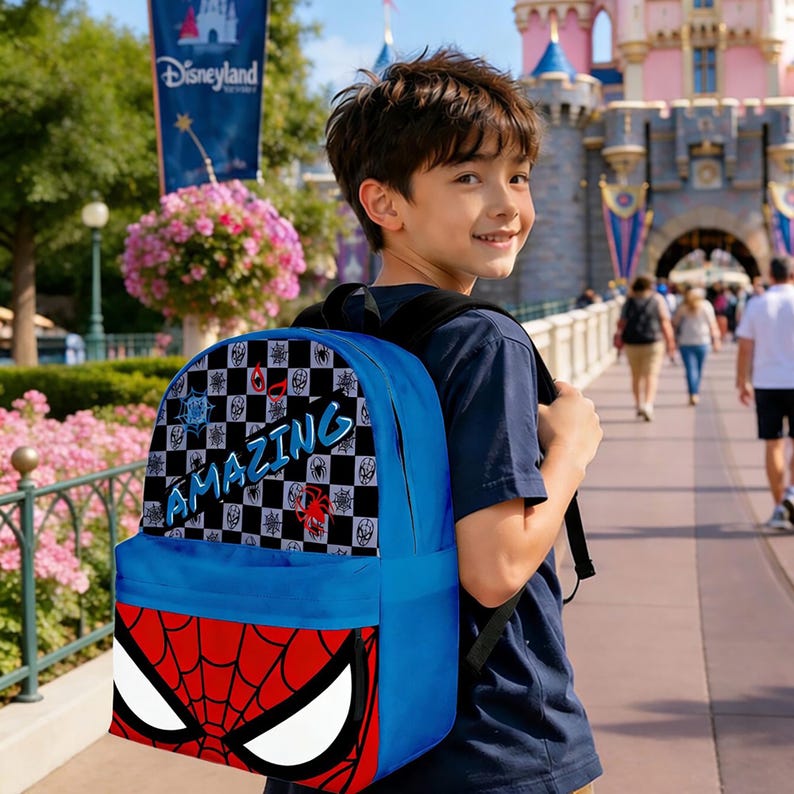 May include: A blue backpack featuring a Spider-Man design. The bottom of the backpack has a red and white Spider-Man mask design. The top of the backpack has a black and white checkered pattern with the word "AMAZING" in blue.