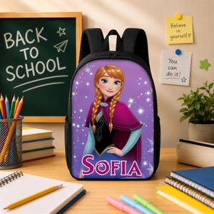 Pu&ograve; includere: Uno zaino nero con una stampa grafica di un personaggio con capelli intrecciati, vestito e mantello viola, circondato da stelle e fiocchi di neve bianchi. Il nome Sofia &egrave; stampato in grandi lettere rosa sulla parte frontale inferiore.