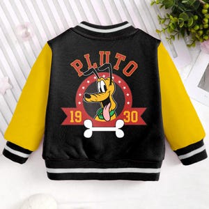 May include: Black and yellow baseball jacket featuring a cartoon image of Pluto the dog. The jacket has a red and white logo that says "Pluto" with the numbers "19" and "30" on either side of the logo.