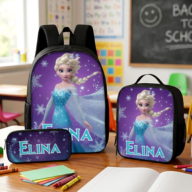May include: A black backpack, lunch bag, and pencil case set featuring a purple background with a graphic of a blonde character in a blue dress and the name ELINA printed in light blue letters, surrounded by white snowflake patterns.