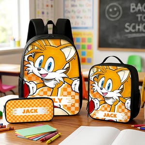 May include: A black backpack, lunch bag, and pencil case set featuring a graphic of the orange character Tails from Sonic the Hedgehog. Each item displays an orange and white checkered pattern and a white rectangular label with the name JACK.