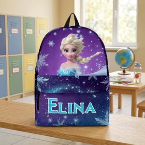 May include: A purple backpack featuring a graphic of a blonde character with a braided hairstyle, surrounded by white snowflake patterns and sparkling light effects. The name ELINA is printed in large, light blue capital letters on the front pocket.