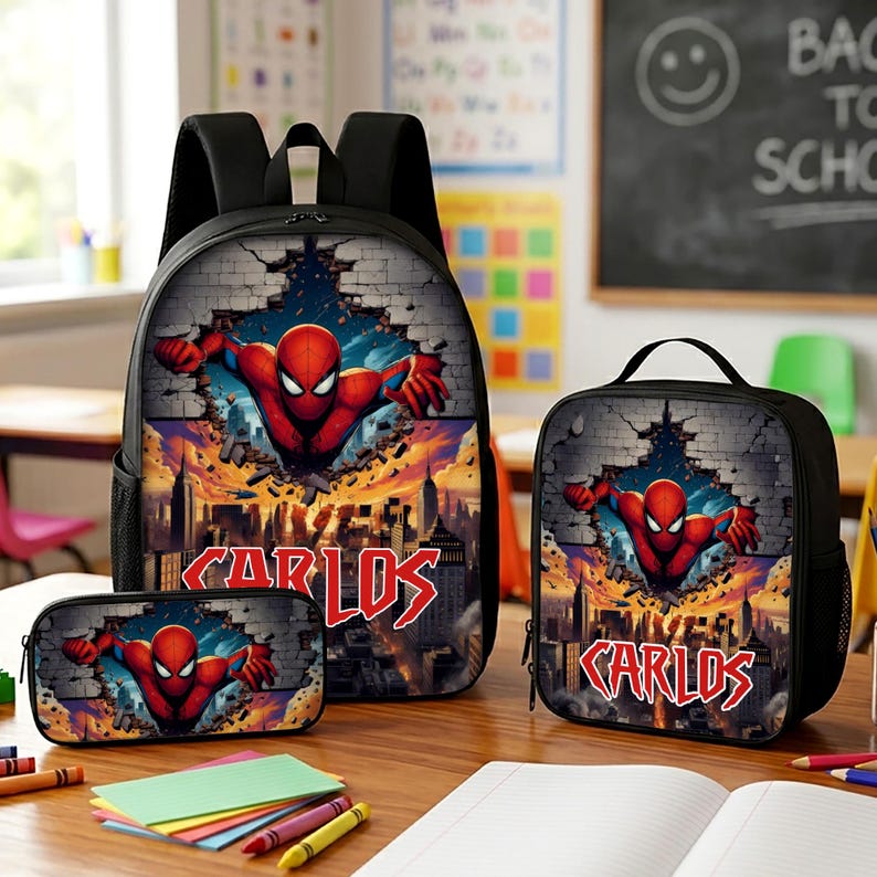 May include: A black backpack, lunch bag, and pencil case set featuring a graphic of Spider-Man bursting through a brick wall above a city skyline. Each item displays the name CARLOS in a bold, red, stylized font against the dark background.