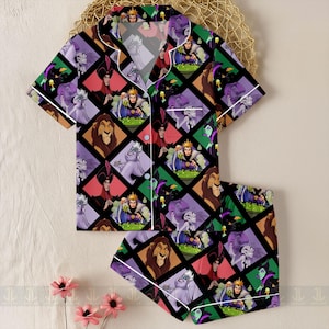 May include: A two-piece pajama set featuring a colorful pattern of cartoon villains. The short-sleeved top and shorts are black with a diamond grid design. Each diamond contains a different character in shades of purple, green, red, and brown. White trim outlines the edges.