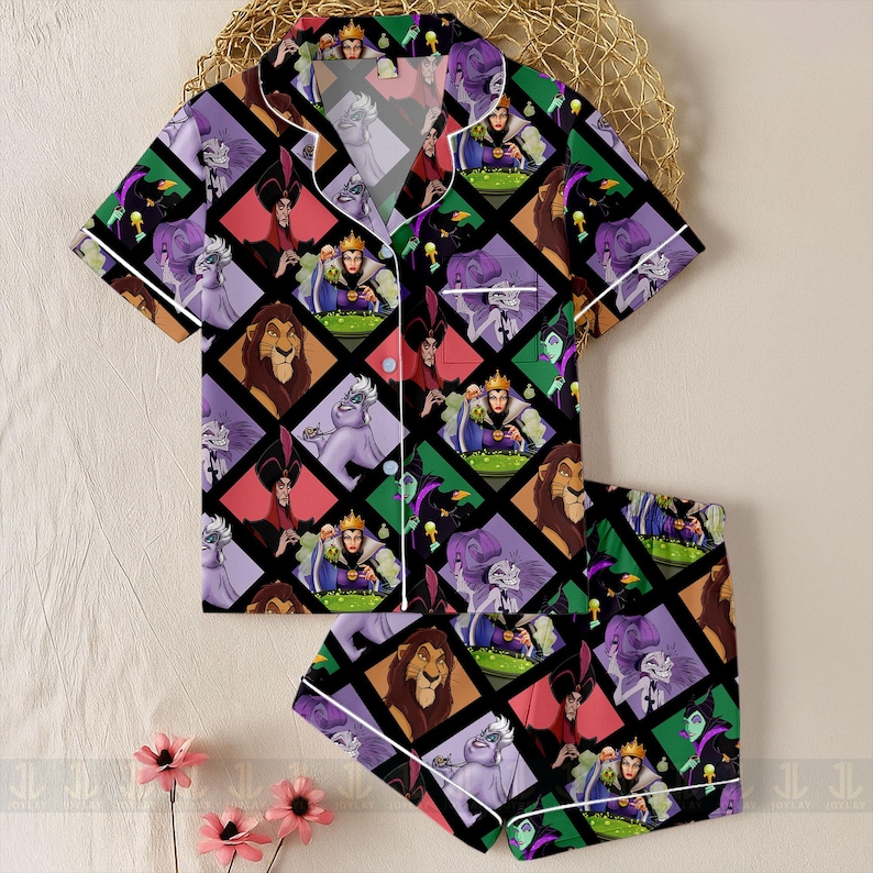 May include: A two-piece pajama set featuring a colorful pattern of cartoon villains. The short-sleeved top and shorts are black with a diamond grid design. Each diamond contains a different character in shades of purple, green, red, and brown. White trim outlines the edges.
