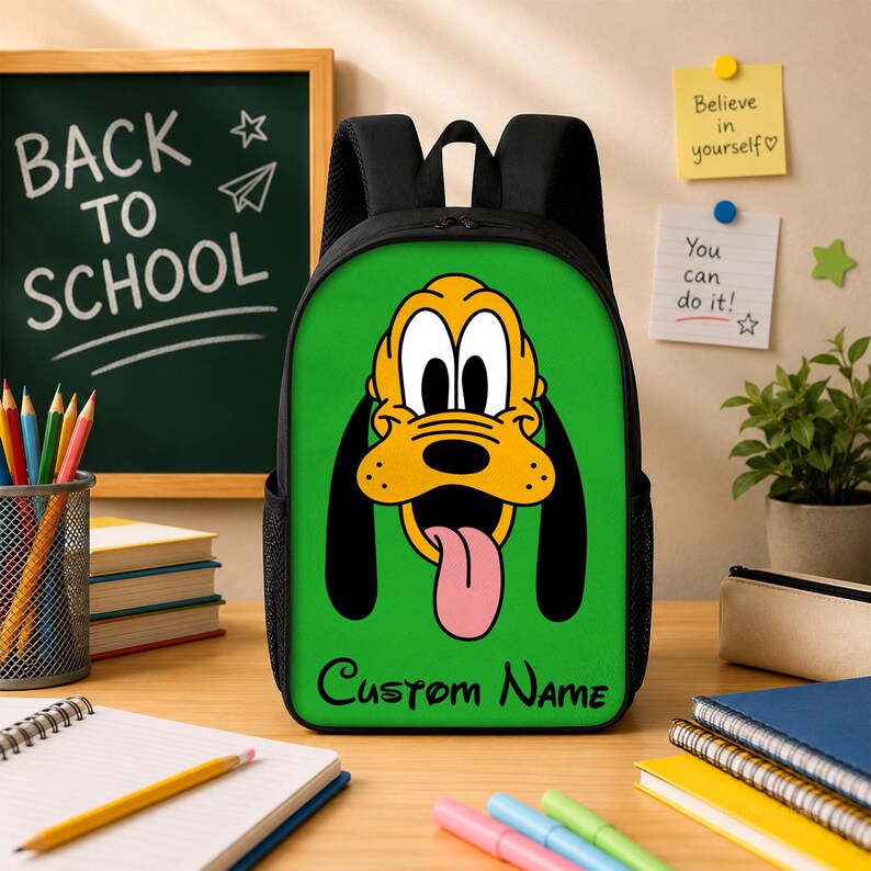 Peut inclure: Un sac &agrave; dos noir avec un panneau avant vert vif orn&eacute; d'une grande illustration du personnage Pluto, dot&eacute; d'un pelage jaune, de longues oreilles noires et d'une langue rose. Le texte Custom Name est imprim&eacute; en noir au bas du panneau.