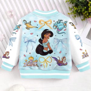 May include: A light blue bomber jacket with a white and light blue patterned design. The jacket features a variety of Disney's Aladdin characters including Jasmine, Genie, Abu, and the magic lamp.