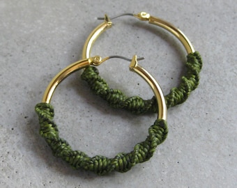 Aros gruesos de oro con detalle de fibra de macramé en color verde oliva. Joyería bohemia moderna y chic.