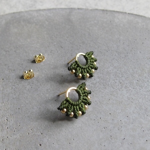 May include: A pair of green and gold earrings with a circular design. The earrings are made of small beads and have a delicate, feminine look.