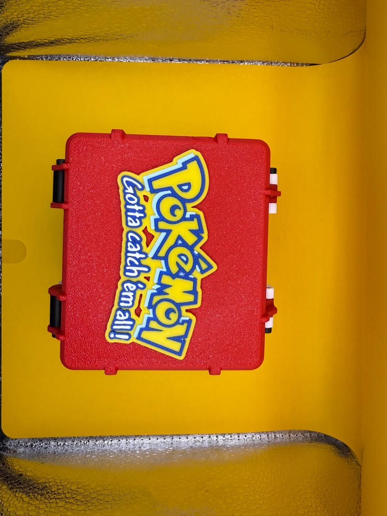 May include: A red plastic case with a Pokemon logo and the text "Gotta catch 'em all!" printed on it.