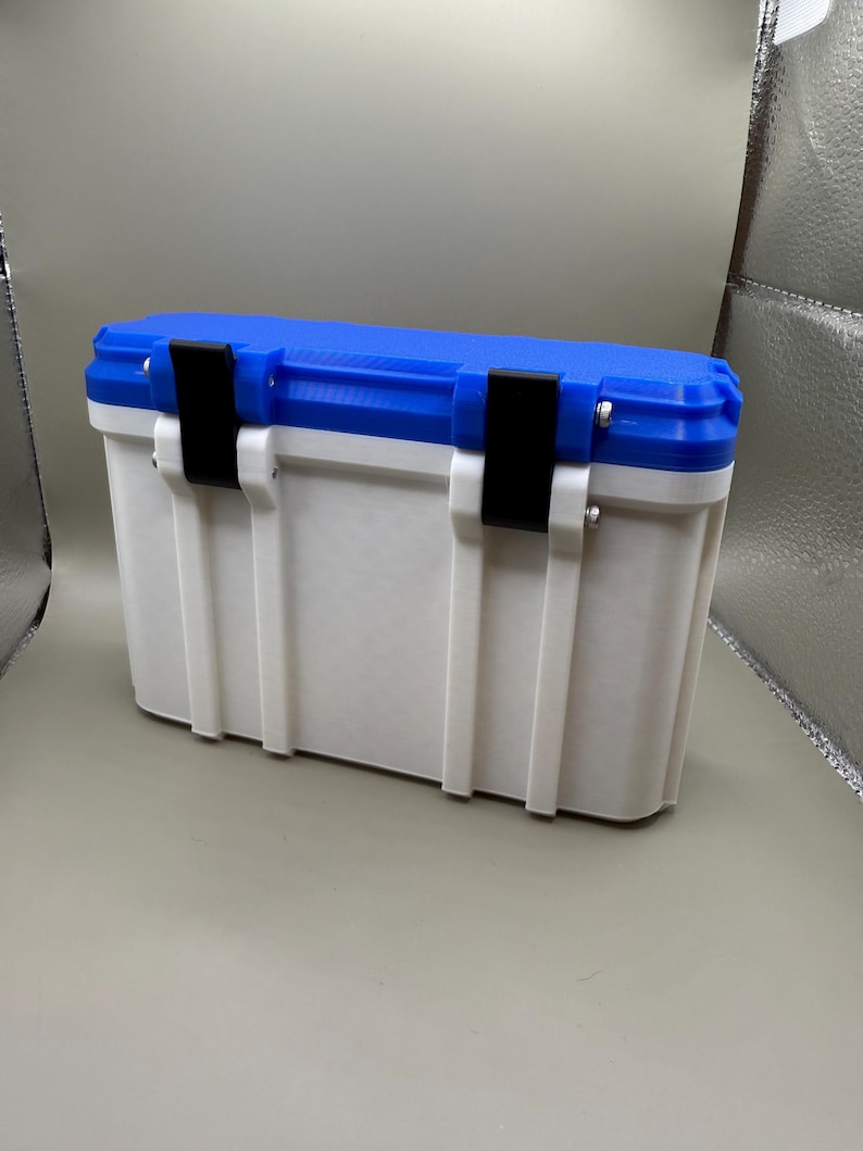 May include: A white and blue plastic storage box with black latches. The box has a textured surface and is closed.