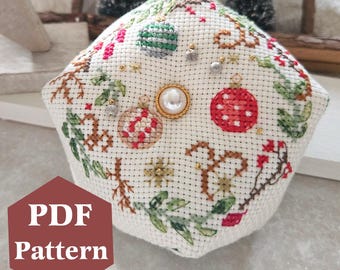 Puede incluir: Tela blanca de forma hexagonal, con un diseño de punto de cruz de adornos navideños, vegetación y detalles dorados. La tela está cosida con un botón de perla en el centro. El texto "PDF Pattern" es visible en la esquina inferior izquierda.
