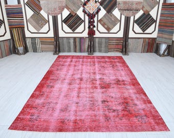 Könnte beinhalten: Ein vintagefarbener, abgenutzter Teppich in Rosa und Rot. Der Teppich hat einen verblassten, abgenutzten Look und ein dezentes Muster.