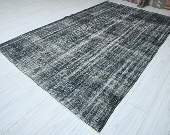 May include: A black and white vintage rug with a distressed look. The rug has a faded, worn appearance with a subtle pattern.
