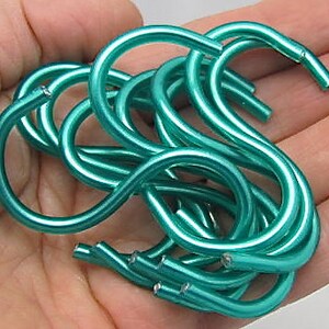 May include: A set of ten teal-colored S-shaped hooks made of metal. The hooks are designed for hanging items in the kitchen, bathroom, or other areas of the home.