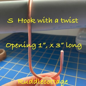 May include: A copper S hook with a twist. The hook is 3 inches long and has a 1 inch opening. The text "S Hook with a twist" and "Opening 1" x 3" long" is visible in the image. The text "Ruddleccottage" is also visible in the image.