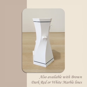 May include: White ceramic vase with a geometric design and black trim. Also available with brown, dark red, or white marble lines.