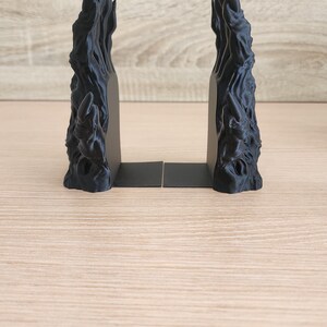 Peut inclure: Deux serre-livres noirs avec un design textur&eacute; et abstrait. Les serre-livres ont une finition sombre et mate et une apparence sculpturale unique. Ils sont con&ccedil;us pour maintenir les livres debout sur une &eacute;tag&egrave;re ou un bureau.