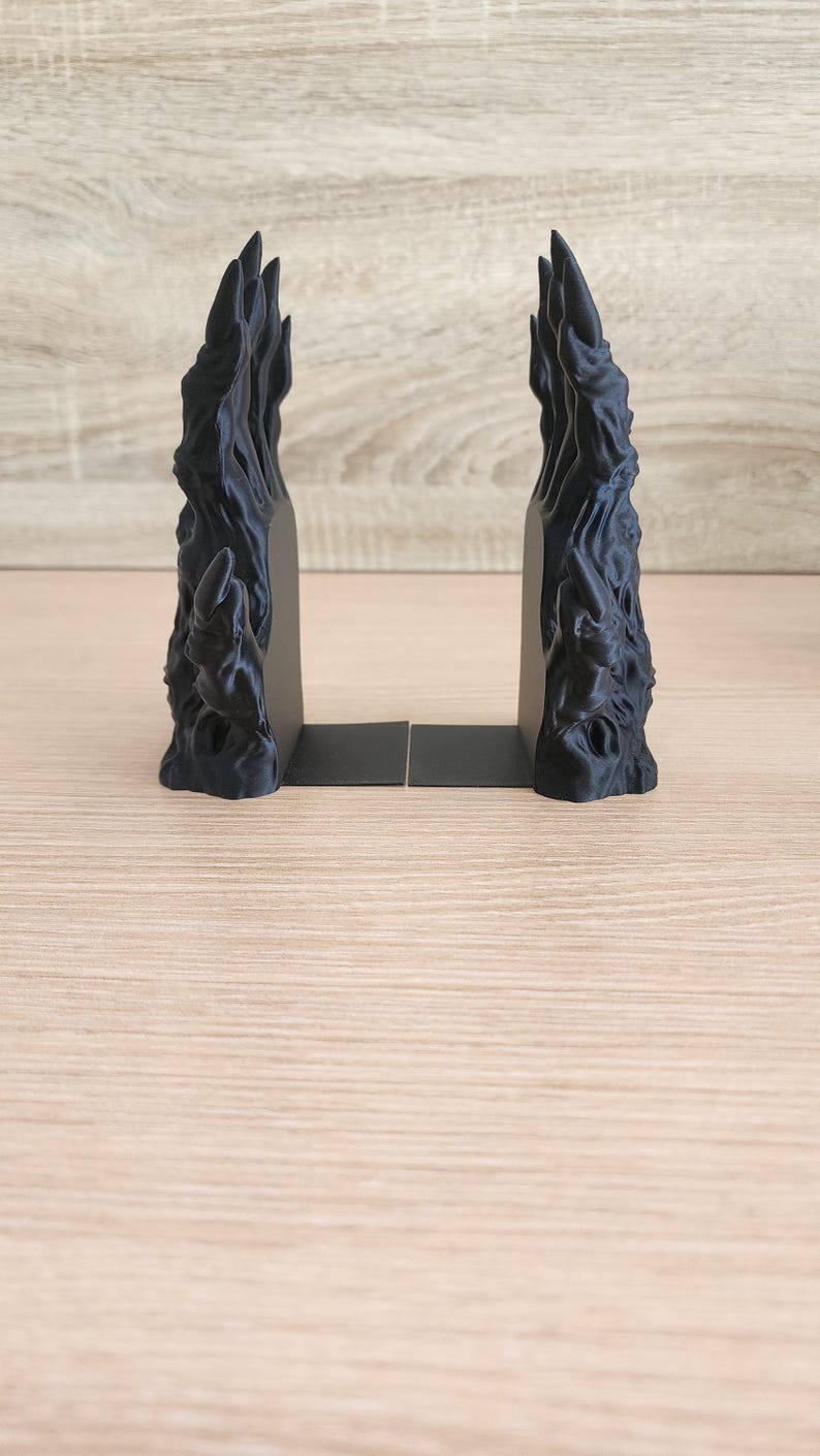 Peut inclure: Deux serre-livres noirs avec un design textur&eacute; et abstrait. Les serre-livres ont une finition sombre et mate et une apparence sculpturale unique. Ils sont con&ccedil;us pour maintenir les livres debout sur une &eacute;tag&egrave;re ou un bureau.