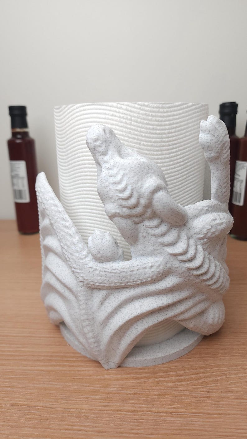 May include: White ceramic paper towel holder shaped like a dragon with a textured surface.
