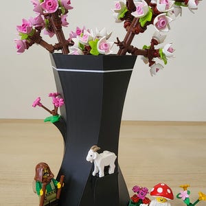 Close-up of black and white LEGO-Compatible Vase with white, pink LEGO flowers and other lego pieces attached