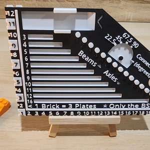 Black and white brick ruler with a brick separator next to the ruler.