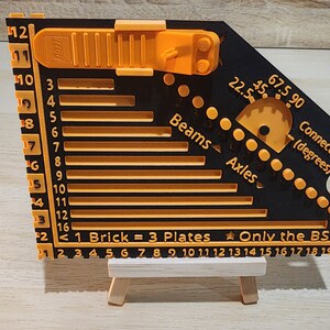 Black and orange brick ruler with a brick separator attached.