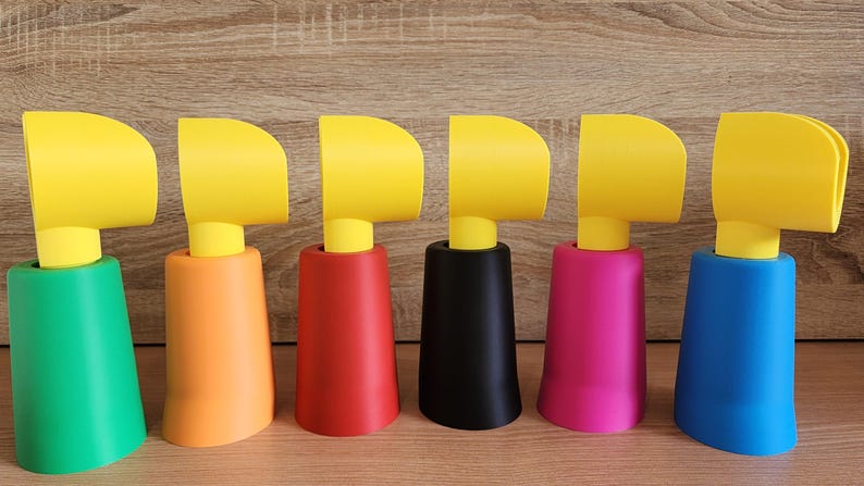 Multiple Minifig-Inspired Controller Stands in various colours lined up on a wooden surface
