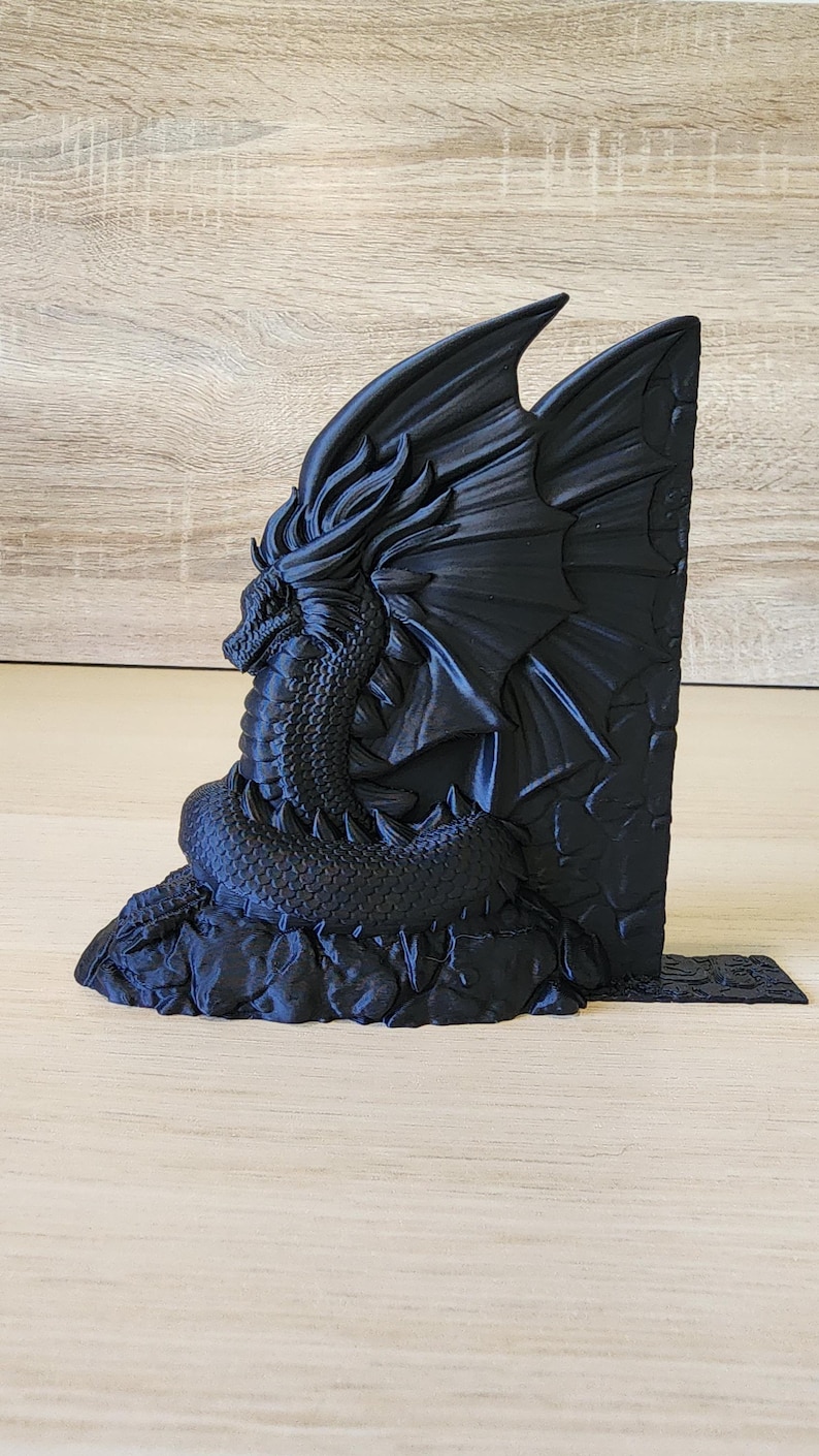 Peut inclure: Un serre-livres en forme de dragon noir avec les ailes d&eacute;ploy&eacute;es, perch&eacute; sur une base rocheuse. Le dragon est tourn&eacute; vers la gauche et pr&eacute;sente une surface textur&eacute;e et d&eacute;taill&eacute;e.
